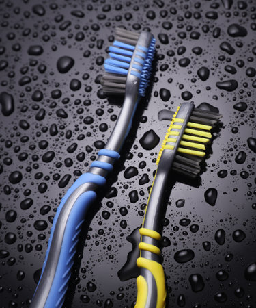 Two toothbrushes in water drops on a black backgroundの写真素材