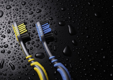 Two toothbrushes in water drops on a black backgroundの写真素材