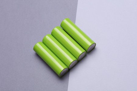 Green AA batteries on a gray backgroundの写真素材