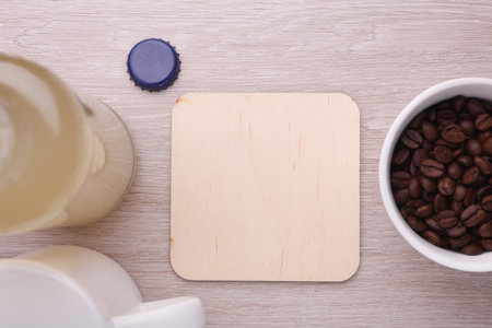 Wooden square drink coasters, cup with coffee beans on the tableの写真素材