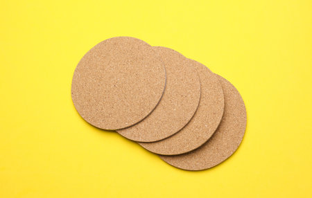 Cork coasters for drinks on a yellow background