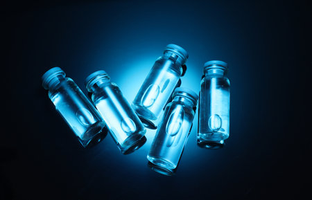 Medical glass vials with liquid in blue neon lightの写真素材