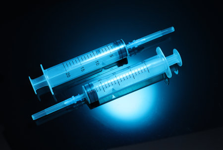 Medical syringe in blue neon lightの写真素材