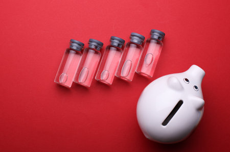 Medical glass vials with liquid on a red backgroundの写真素材