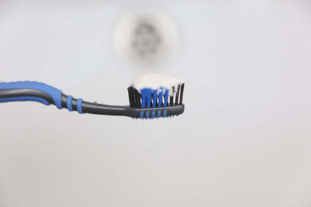 Toothbrush with toothpaste over sink close upの写真素材
