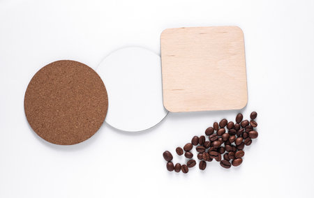 Cork, white, wooden coasters for drinks and coffee beans on white backgroundの写真素材