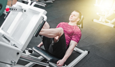 Athletic man doing exercise press leg machine in gym. Power trainingの写真素材
