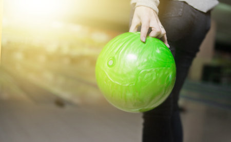 Woman's hand holds green bowling ball ready to throwの写真素材