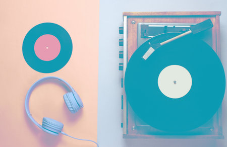Retro vinyl record player, headphones on pink gray background. Top view. Retro style. Flat lay.の写真素材