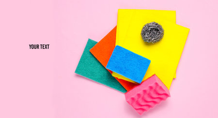 Home and bathroom cleaning kit on pink background. Sponges, abrasives.