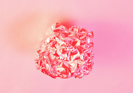 Crumpled foil ball. Holographic red light. Top view, surrealism