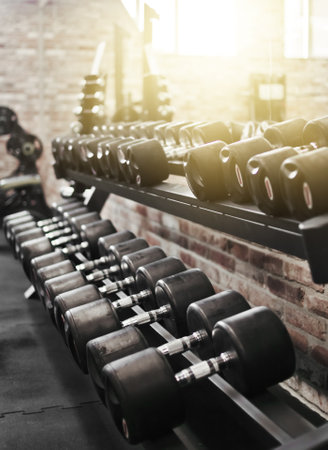 Set of black dumbbell with metal handles on a rack in the gym. Free weights training, bodybuildingの写真素材