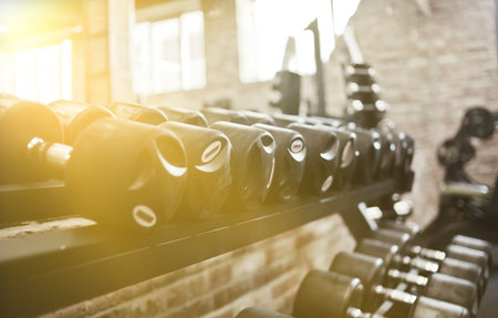Set of black dumbbell with metal handles on a rack in the gym. Free weights training, bodybuildingの写真素材