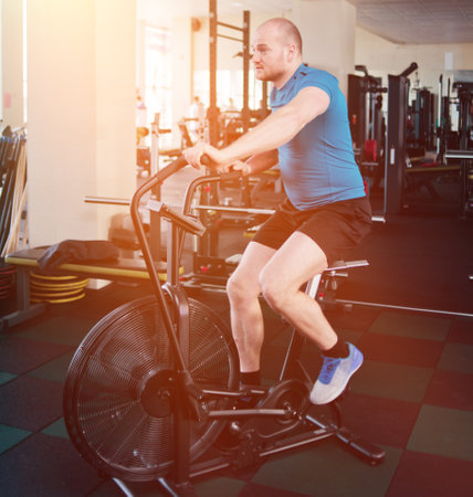 Powerful man trains with air bike. Functional training conceptの写真素材