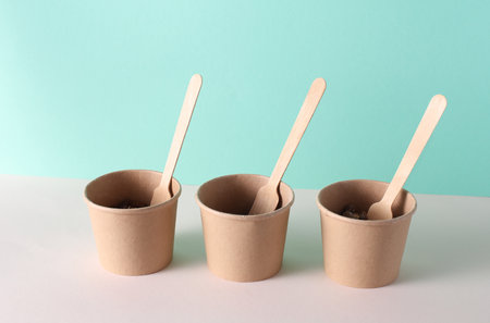 Eco cardboard round food boxes with forks on table, mint green backgroundの写真素材
