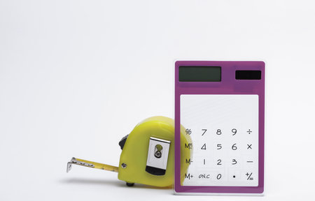 Calculator with construction tape measure on white backgroundの写真素材