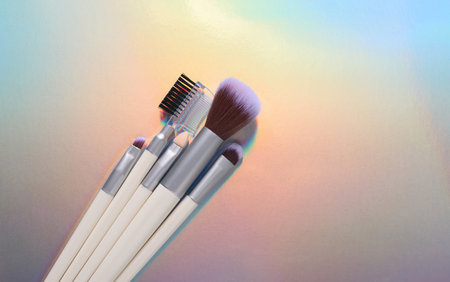 Makeup brushes on holographic color backgroundの写真素材