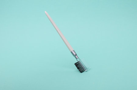 Makeup brush for eyebrows floating on mint green backgroundの写真素材