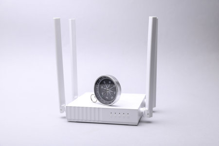 Modern four-antenna Wi-Fi router and compass on gray background.の写真素材