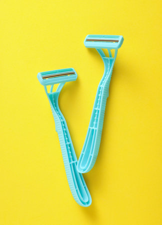 Blue disposable razors on yellow background