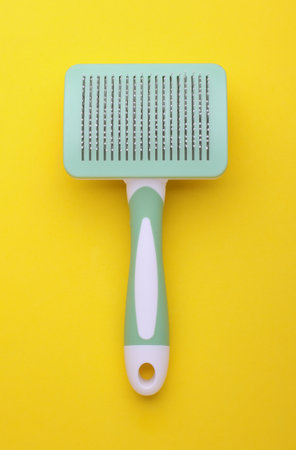 Pet hair brush on a yellow backgroundの写真素材