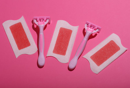 Razors and epilation strips on a pink background