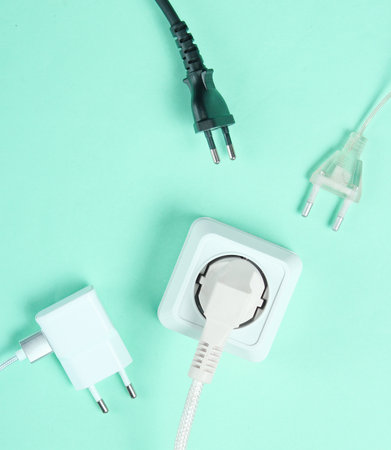 The concept of electrical dependence. Lots of power plugs near power outlets on blue background