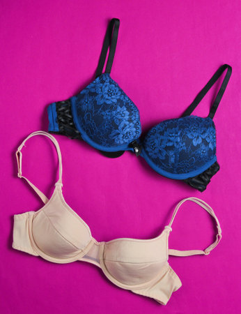Two fashionable women's bra on pink background. Beautiful underwear. Top viewの写真素材