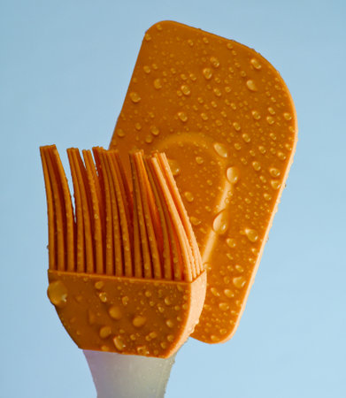 Silicone kitchen brush and spatula on blue backgroundの写真素材