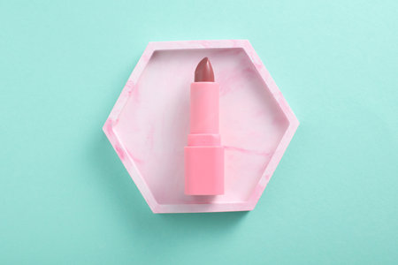 Tube of pink lipstick in tray on mint green background. Minimalism. beauty still lifeの写真素材