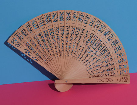 Traditional wooden Asian hand fan on pink blue backgroundの写真素材