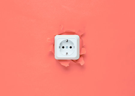 Socket through a torn hole of coral background, minimalismの写真素材
