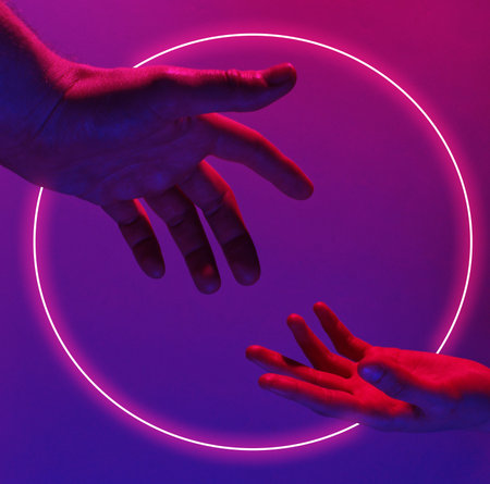 Two hands reach out to each other with pink violet neon light. Minimalism fashion. Surrealism. Concept artの写真素材