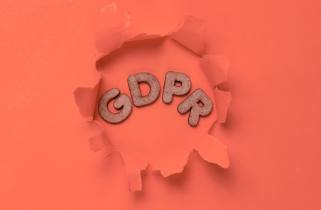 The word GDPR in a torn hole of orange background. Top viewの写真素材
