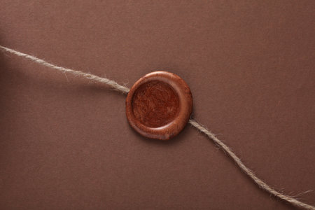 Wax seal with thread on brown background