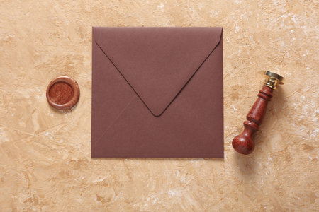 Envelope with wax seal and vintage stamp on beige concrete background. Gift certificate, wedding...