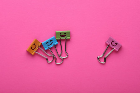 Binder clips with a smiling face on pink backgroundの写真素材
