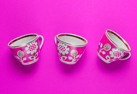 Three retro ceramic cups on pink background. Top viewの写真素材