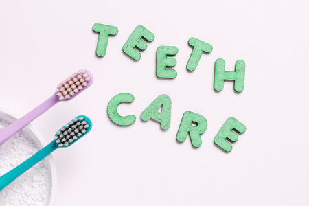Two toothbrushes, tooth powder on white background with slogan teeth care. Minimalism oral hygiene...