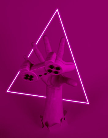 Female hand catches gamepad through torn paper. Neon light. 80s