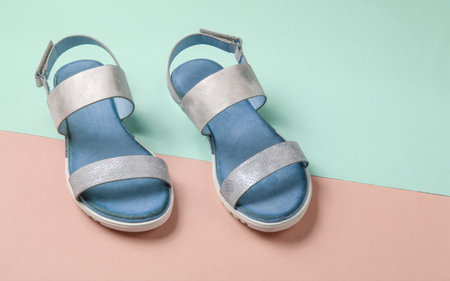 Leather female sandals on a pastel blue-pink background. Summer footwear