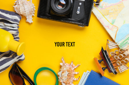 Traveler accessories, retro camera on a yellow background. Trip on the beach, vacation. Summer minimalistic background. Flat lay tourism allegory. Top view. Copy spaceの写真素材