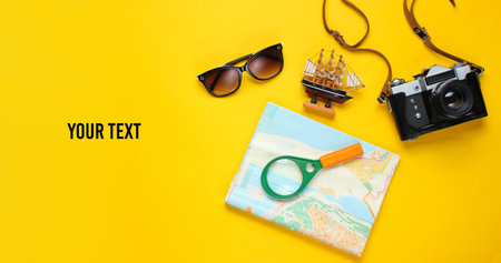 Traveler accessories, retro camera on a yellow background. Trip on the beach, vacation. Summer...