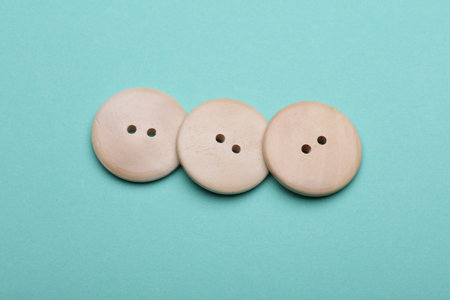 Wooden buttons on mint green background close upの写真素材