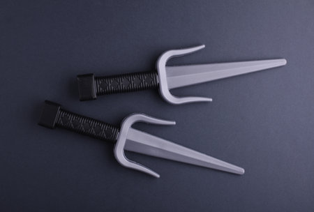 Toy plastic sai weapons on gray backgroundの写真素材