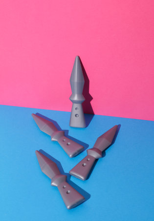 Toy ninja throwing weapons on pink blue backgroundの写真素材