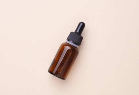 Glass Bottle of Facial Serum on Beige Backgroundの写真素材