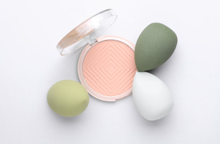 Colored Makeup Sponges and Powder Palette on gray Background. Beauty concept