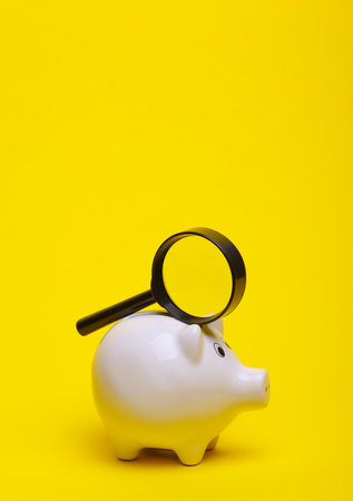 Ceramic white piggy bank on a yellow background. Conceptual photoの写真素材