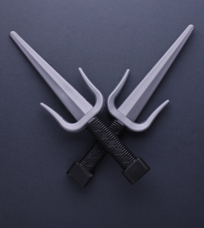 Toy plastic sai weapons on gray backgroundの写真素材